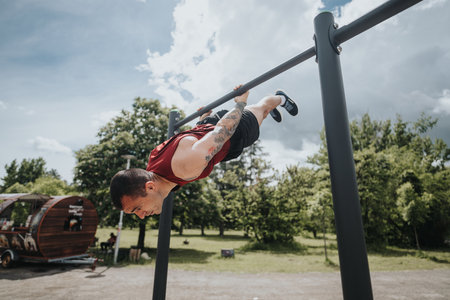 Athletic man performing advanced calisthenics in a sunny park