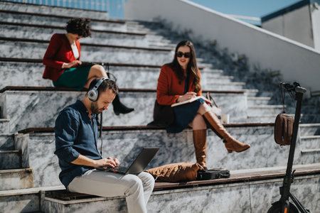 Diverse business professionals engaged in an outdoor meeting on sunny stairsの写真素材