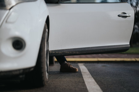 Close-up of dirty white car door with persons legs in backgroundの写真素材