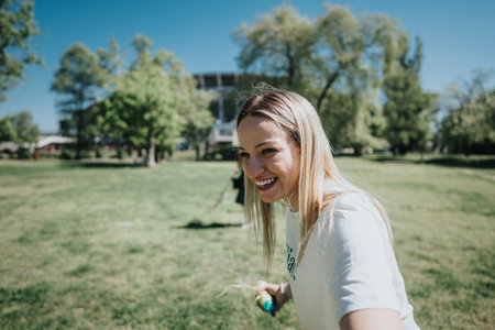 Friends enjoying a sunny day in the park flying a kite, capturing moments of joy and friendshipの写真素材