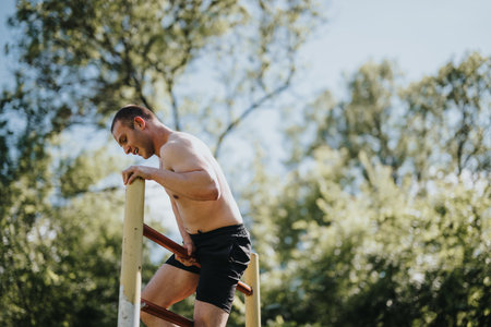 Man practicing calisthenics in nature on a sunny dayの写真素材