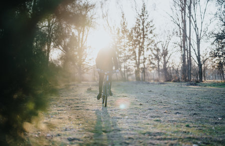 Man enjoys a peaceful bicycle ride in a scenic park during a sunny afternoon