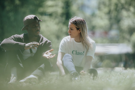 Carefree friends enjoying conversation on a sunny day in the parkの写真素材
