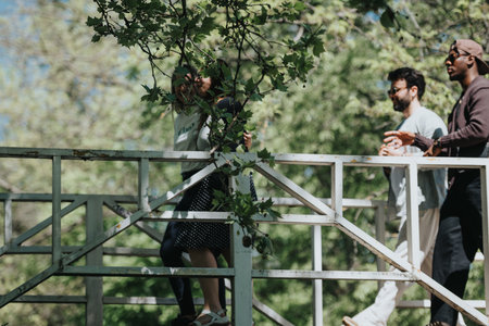 Multiracial friends enjoying a sunny day together in an urban park, expressing carefree joy and...