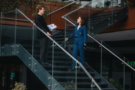 Businesspeople having a conversation on a modern office staircaseの写真素材