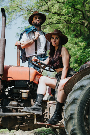 Rural fashion couple posing on a vintage tractor in the countryside