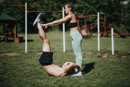 Fitness training session in an urban park with two people exercising togetherの写真素材