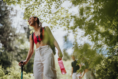 Young woman hiking in nature with friends, enjoying the summer dayの写真素材