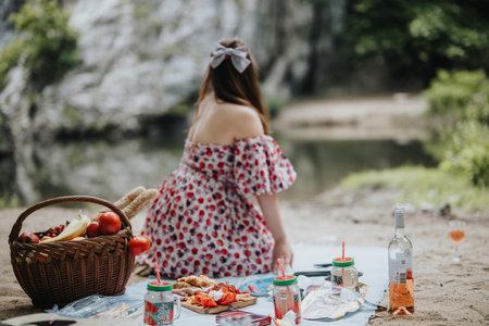 Woman enjoying a serene picnic by a river in natureの写真素材
