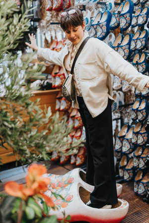 Person balancing in large wooden clogs in souvenir shop surrounded by colorful traditional shoes