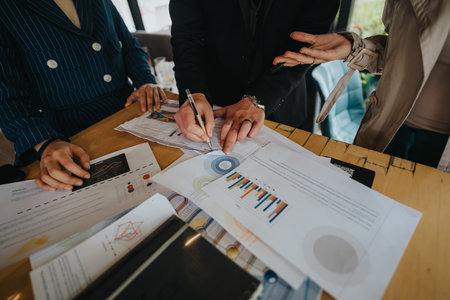 Team collaborating on business project with charts and graphs in modern officeの写真素材