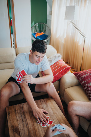 Young friends enjoying a fun game of playing cards in a cozy living room settingの写真素材