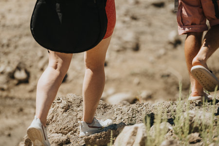 Close-up of two people hiking by the lake in casual clothes on a sunny day
