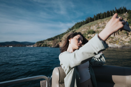 Young woman enjoying a relaxing boat trip with friends over the weekendの写真素材