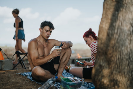 Friends enjoying a picnic in nature at mountain campsite, relaxing and embracing adventure