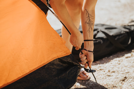 Setting up tent by the lake for an outdoor adventureの写真素材