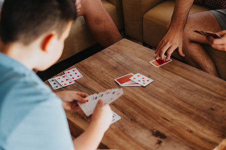 Boys playing a game of cards at a wooden table in a cozy home setting