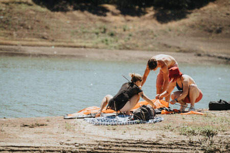 Friends enjoying a picnic near the lake on a sunny dayの写真素材