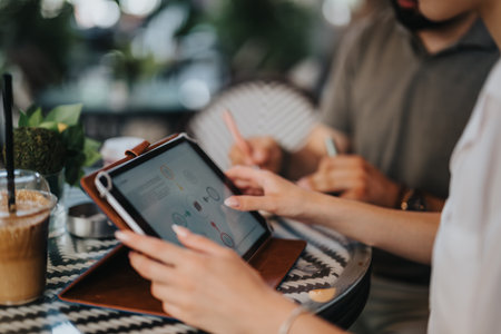 Business meeting in a coffee shop with digital tablet and documentsの写真素材