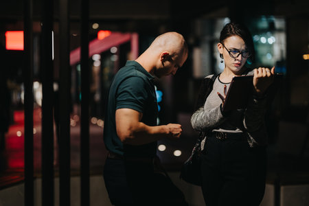 Business professionals discussing work on a tablet late at night