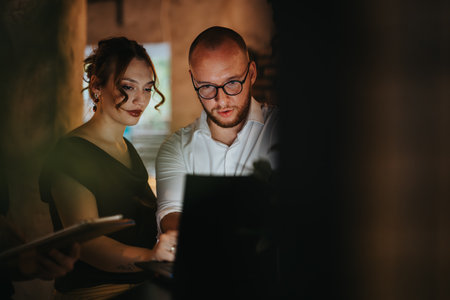 Business colleagues analyzing data on laptop during a meeting in a dimly lit room