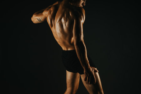 Fit man showing his back muscles in a powerful poseの写真素材
