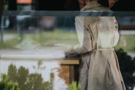 Business meeting behind glass window with documents and charts on deskの写真素材