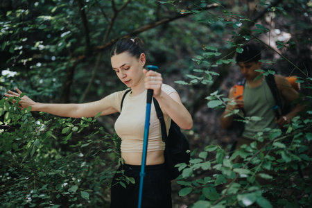 Young friends hiking through a lush forest on a sunny summer day