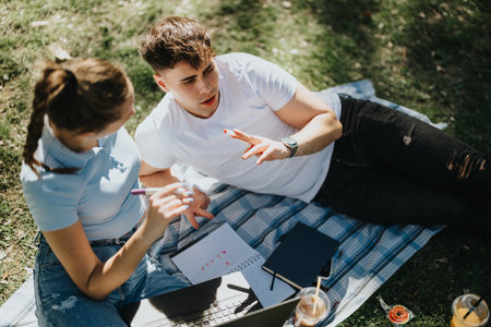 Students studying together outdoors on a sunny dayの写真素材