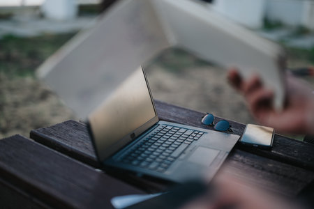 Outdoor business work setup with laptop, smart phone, and notebookの写真素材