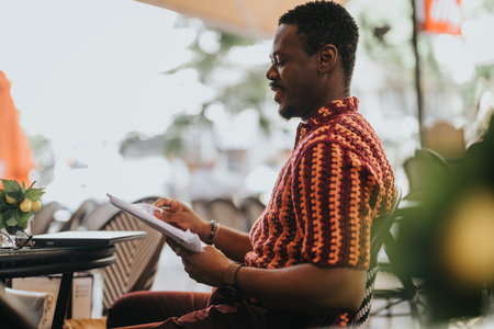 Man in coffee shop reviewing documents during business meeting outdoors