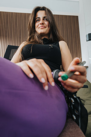 Young woman smiling and relaxing on a bean bag chair in a modern apartment
