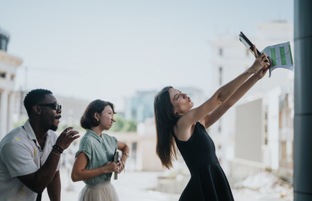 Multicultural business team taking a selfie during an outdoor meeting in an urban city areaの写真素材
