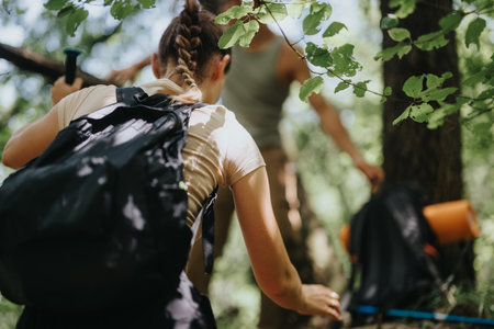 Young friends hiking together in forest on a sunny summer dayの写真素材
