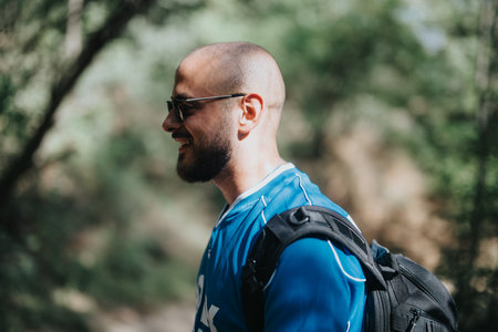 Smiling man with backpack enjoying outdoor adventure in natureの写真素材