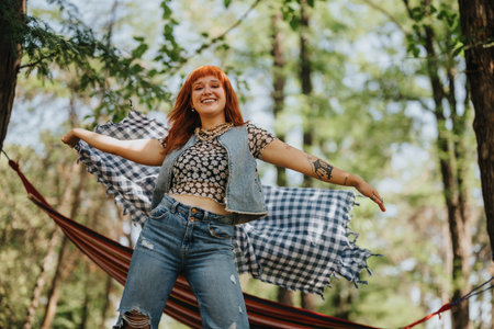 Happy woman enjoying a sunny day in the park with a hammock backgroundの写真素材