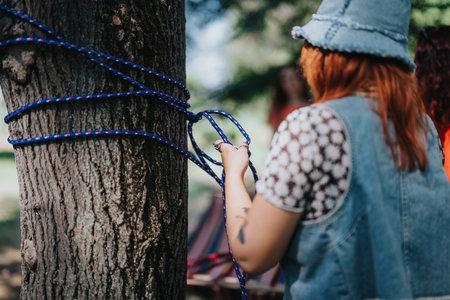 Friends setting up a hammock on a tree outdoors on a sunny dayの写真素材
