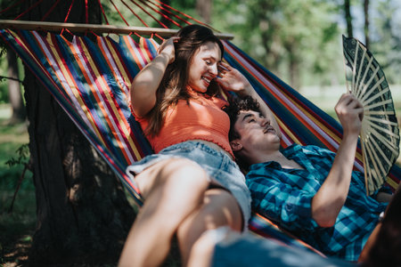 Young couple enjoying a relaxing day together in a colorful hammockの写真素材