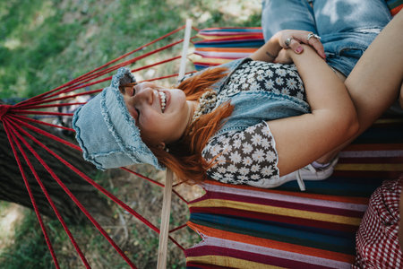 Woman relaxing on colorful hammock in sunny parkの写真素材