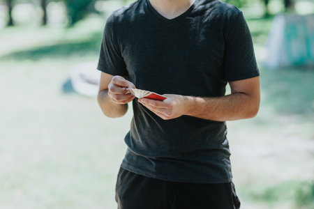 Close-up of a person holding playing cards outdoors in daylightの写真素材