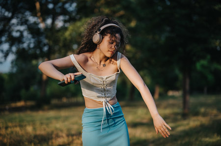 Graceful dancer enjoying modern dance in a sunny park settingの写真素材