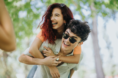 Young adults enjoying a sunny day in park, smiling and having fun outsideの写真素材