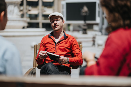 Young business associates having an outdoor meeting while using digital tabletsの写真素材