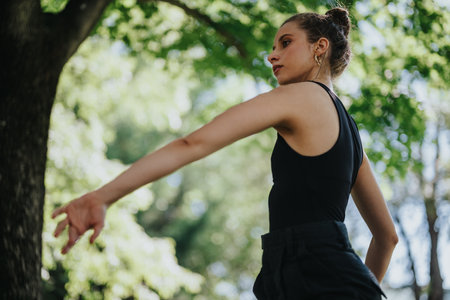 Young woman dancing gracefully in nature, performing modern danceの写真素材