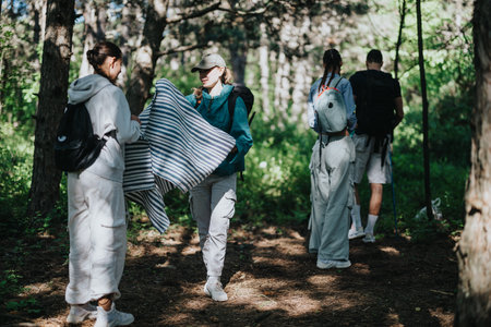 Group of friends hiking in forest carrying camping gear and enjoying natureの写真素材