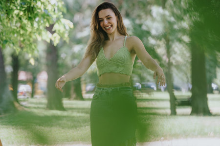 Young adult woman enjoying a sunny day in the park with a joyful smile