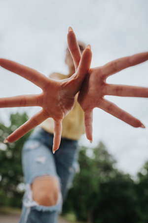 Playful perspective of persons hands reaching toward camera with blurred backgroundの写真素材