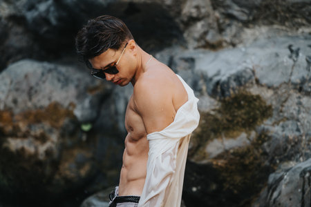 Young man with sunglasses posing outdoors in natureの写真素材