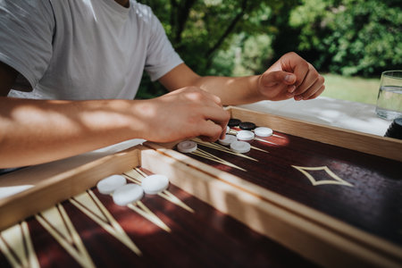 Person playing backgammon outdoors on a sunny dayの写真素材