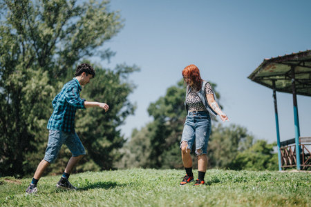 Group of friends having fun and playing in a sunny park near a fountainの写真素材